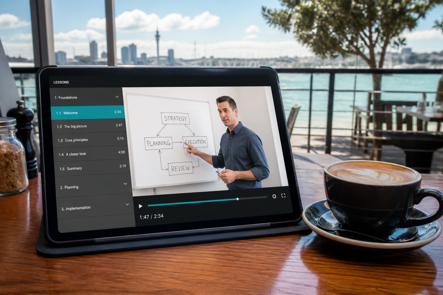Sunny Auckland cafe with a tablet showing an original eLearning course and video lesson