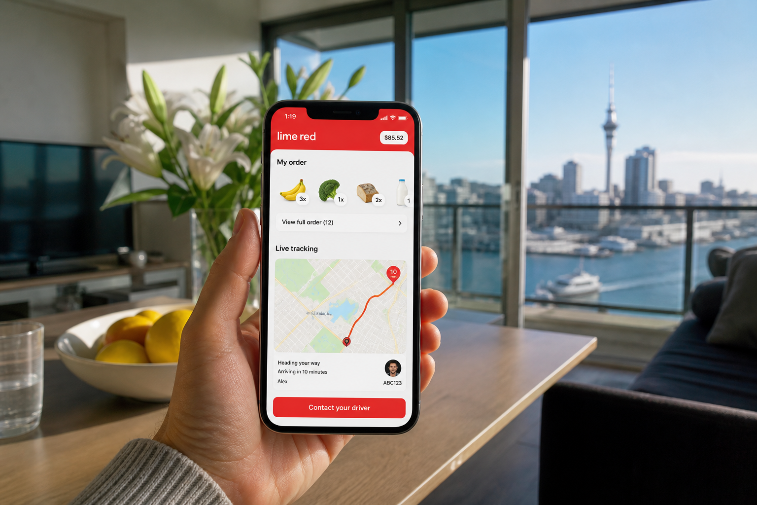 Sunny Auckland apartment with a phone showing original grocery cart and live order tracking