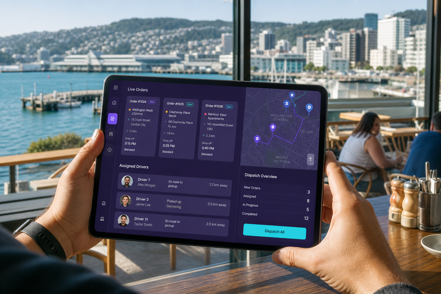 Bright Wellington waterfront with a tablet showing original last mile orders, dispatch and driver assignment