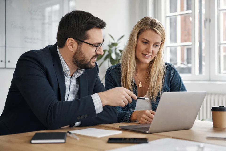 UK store owner and consultant reviewing payment security and fraud alerts on a laptop