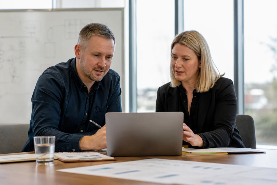 UK business owner and CMS consultant reviewing development costs and content workflows on a laptop