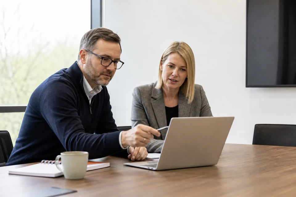 UK business owner and software consultant reviewing a custom software budget and timeline