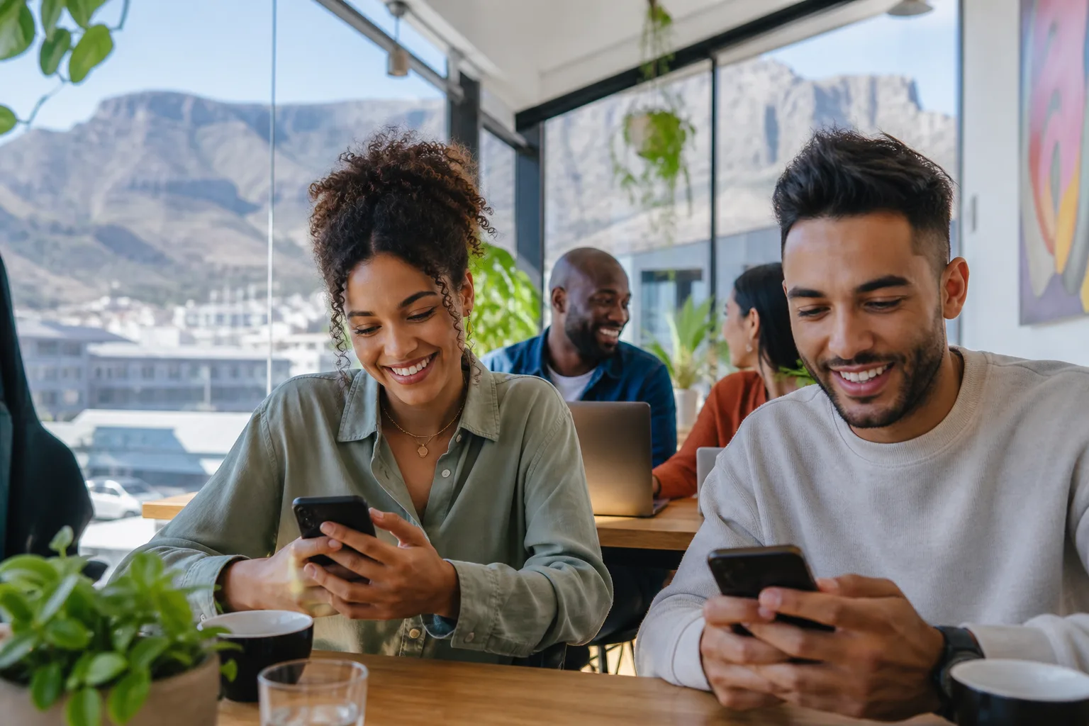 Young professionals in a bright Johannesburg café using dating apps on smartphones