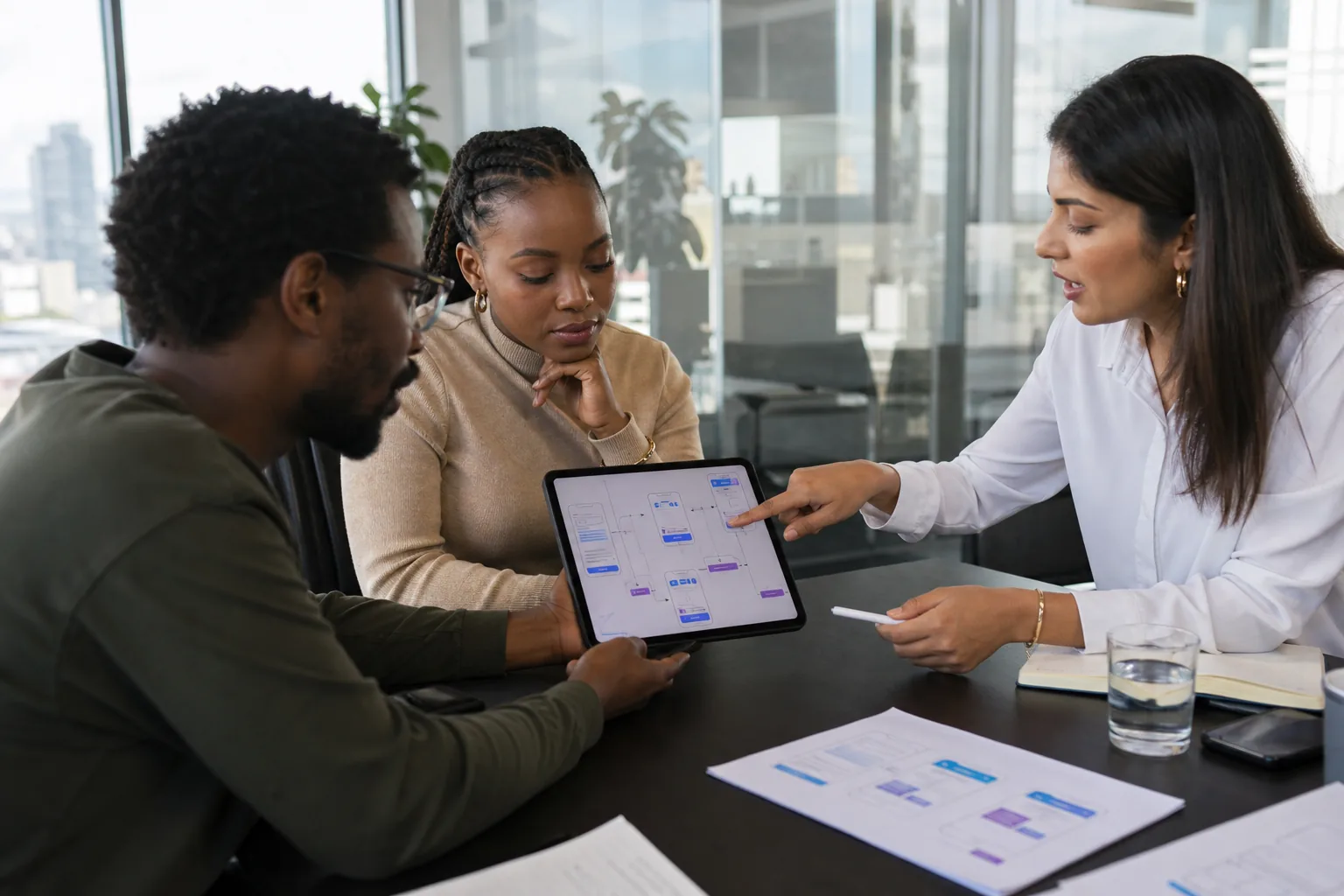 South African product design team reviewing an interactive mobile app prototype on a tablet in a Sandton office