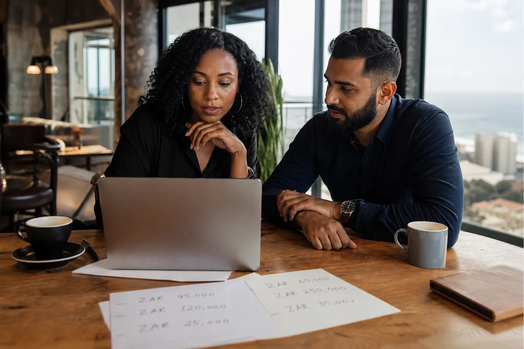 Founder and consultant reviewing a real estate app development budget in South African Rand